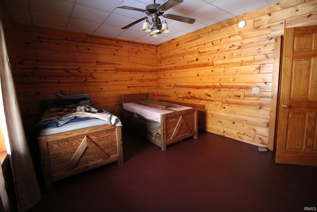 bedroom featuring wood walls and a ceiling fan