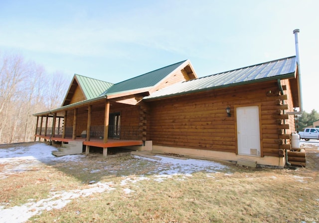 view of home's exterior featuring metal roof and log siding