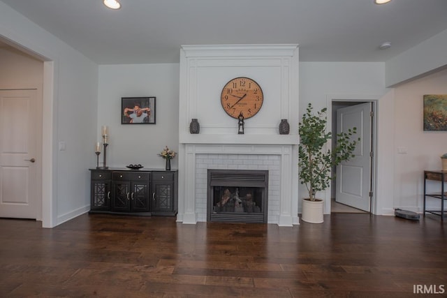 unfurnished living room with recessed lighting, dark wood-style flooring, a fireplace, and baseboards