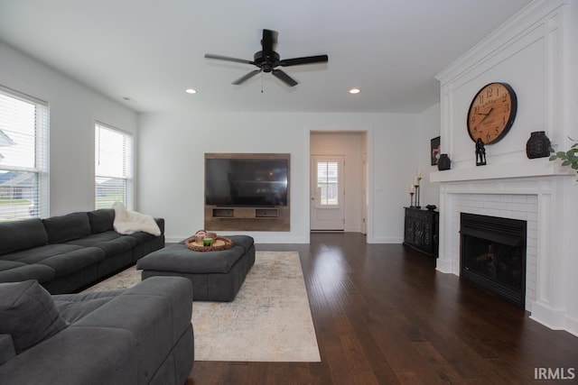 living area featuring plenty of natural light, a fireplace, dark wood finished floors, and recessed lighting