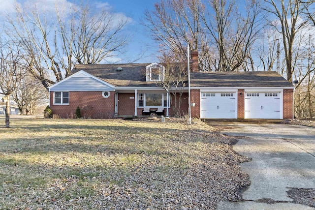 view of front of house featuring driveway, brick siding, a chimney, and an attached garage