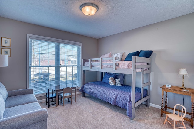 bedroom featuring a textured ceiling, carpet, and baseboards