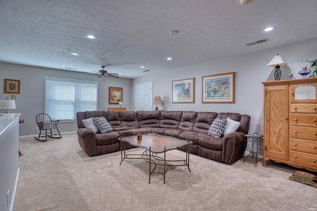 living room featuring a textured ceiling, recessed lighting, light carpet, visible vents, and baseboards