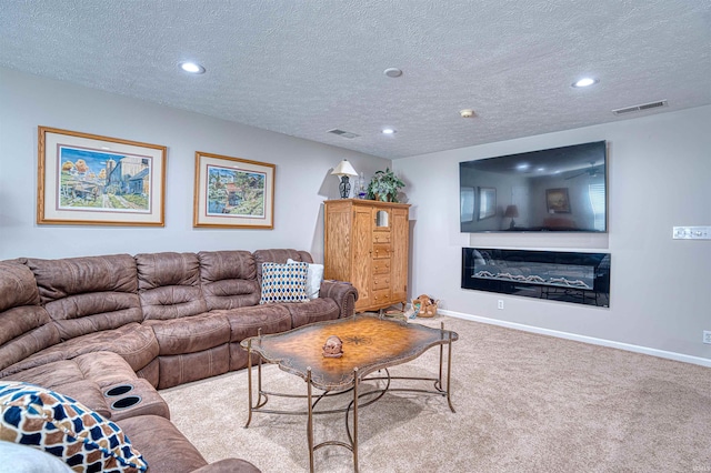 living area with light carpet, baseboards, visible vents, and a glass covered fireplace