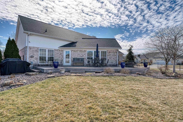 back of house with a patio area, a yard, and brick siding