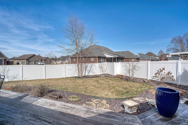 view of yard with a deck, a fenced backyard, and a residential view