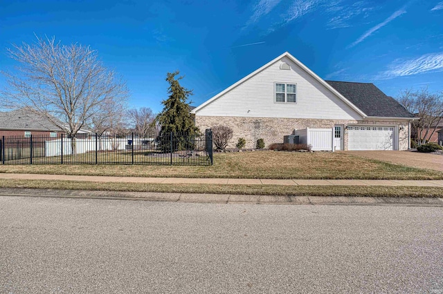 view of property exterior with brick siding, a yard, concrete driveway, an attached garage, and fence