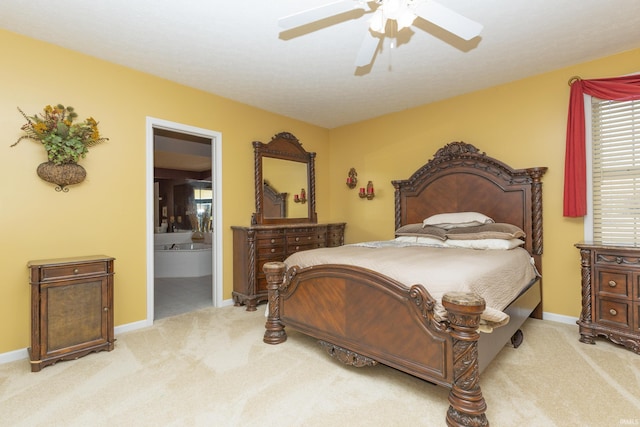 bedroom with light carpet, baseboards, and connected bathroom