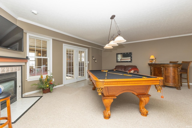 rec room featuring light carpet, pool table, a fireplace with flush hearth, french doors, and ornamental molding