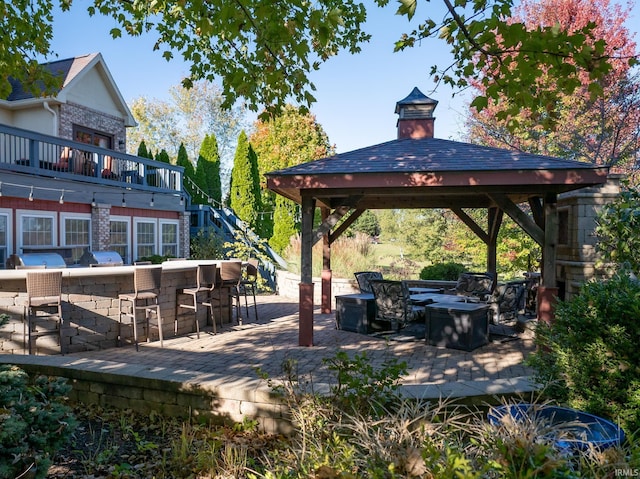 view of patio / terrace with grilling area, a wooden deck, outdoor dry bar, and a gazebo