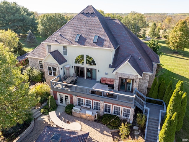 view of front of house with stone siding, stairway, a deck, french doors, and an outdoor living space