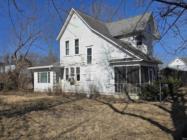 back of house featuring cooling unit, a sunroom, and roof with shingles