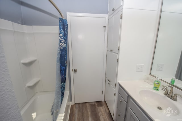 bathroom with shower / bathtub combination with curtain, wood finished floors, and vanity