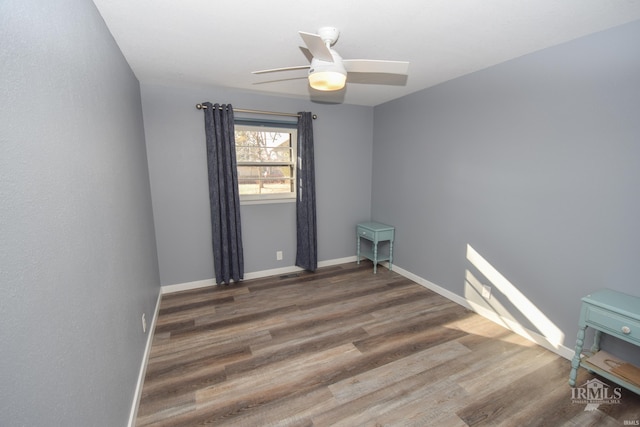 unfurnished room featuring ceiling fan, baseboards, and dark wood-style flooring