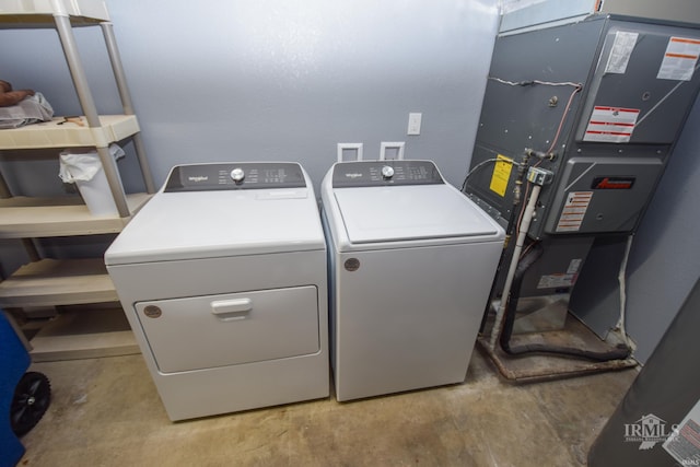 clothes washing area featuring laundry area, independent washer and dryer, and heating unit