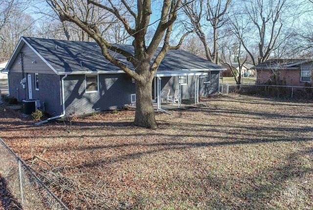 exterior space with central AC unit, fence, and a detached carport