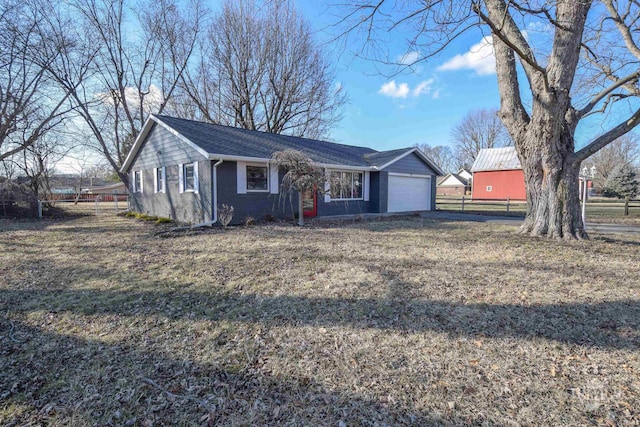 ranch-style home with driveway, an attached garage, fence, a front lawn, and brick siding