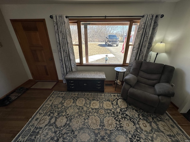 living area featuring dark wood-style floors, plenty of natural light, and baseboards