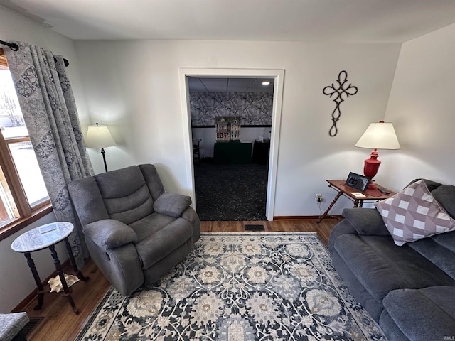 living area featuring visible vents, baseboards, and wood finished floors