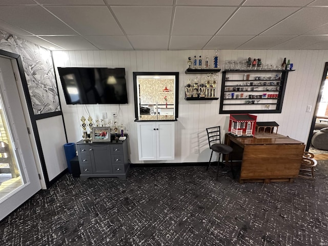 bar featuring dark colored carpet and a drop ceiling