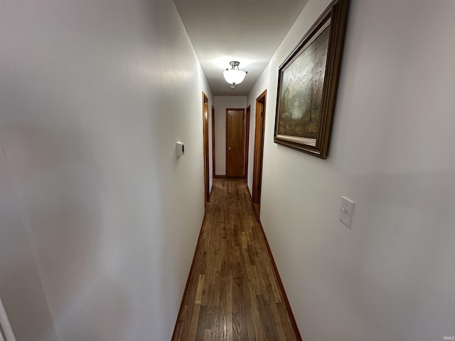 hallway featuring baseboards and wood finished floors