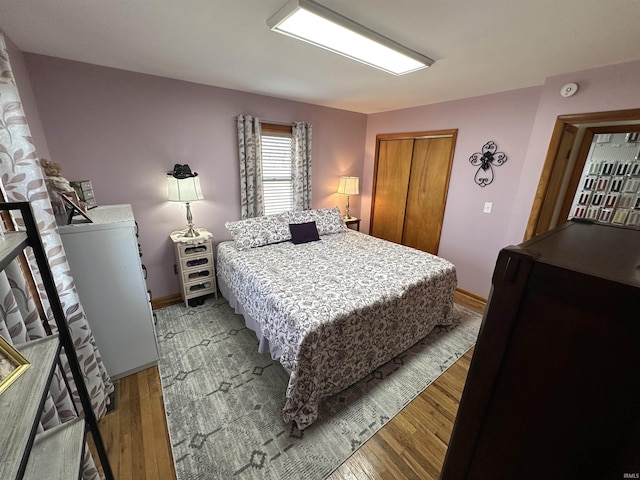 bedroom featuring light wood finished floors, a closet, and baseboards