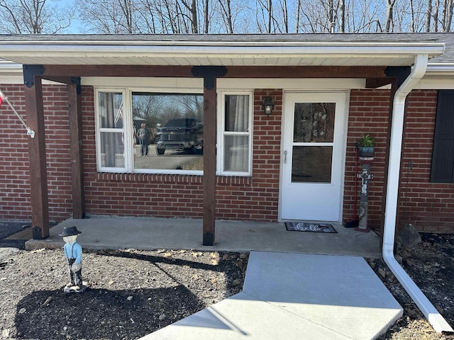 entrance to property featuring brick siding