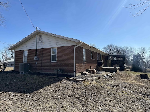 view of home's exterior featuring brick siding and central AC unit