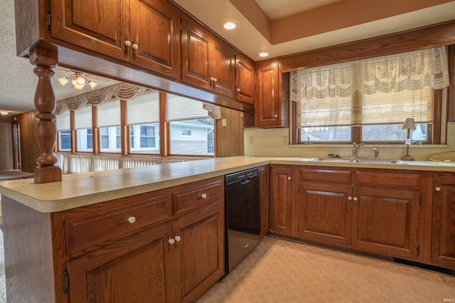 kitchen with dishwasher, light countertops, and a peninsula