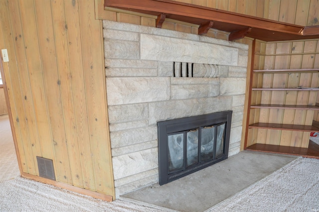 room details with visible vents, carpet flooring, and a stone fireplace