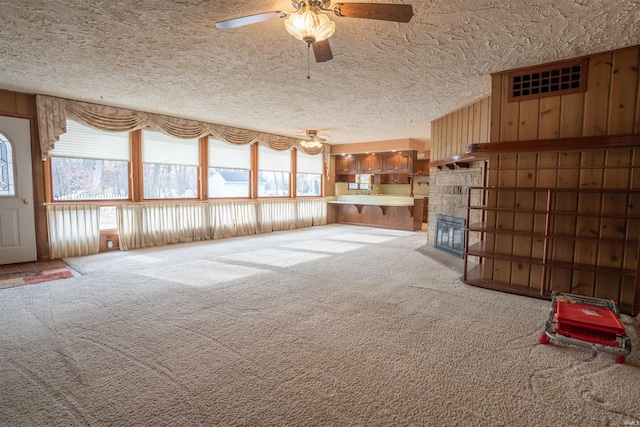 unfurnished living room with carpet floors, plenty of natural light, and a textured ceiling