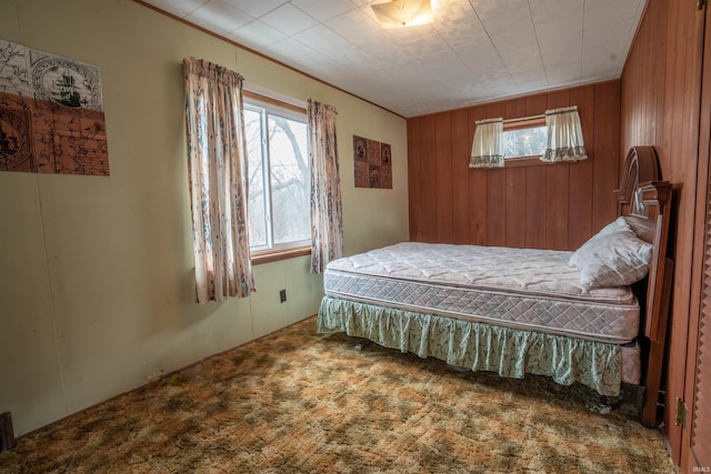 carpeted bedroom with wood walls