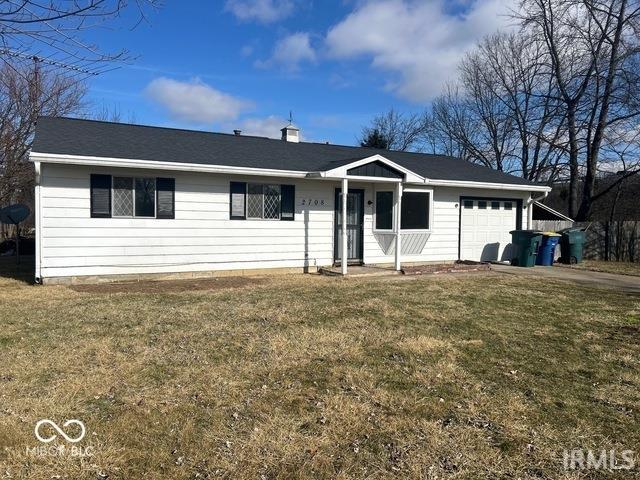 single story home featuring an attached garage and a front yard