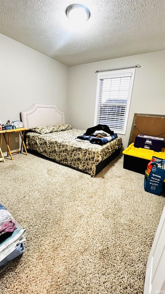 bedroom featuring a textured ceiling and carpet floors