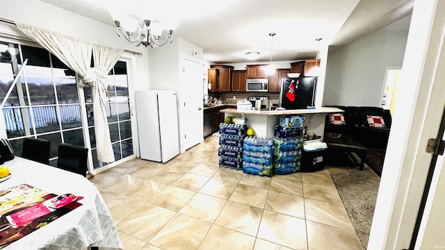 kitchen featuring a breakfast bar area, light countertops, appliances with stainless steel finishes, hanging light fixtures, and decorative backsplash