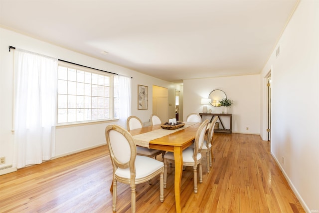 dining area featuring light wood-style floors and baseboards