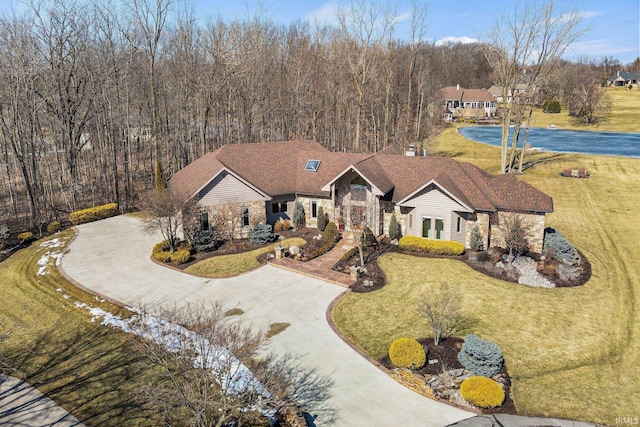 view of front facade with curved driveway and a front yard