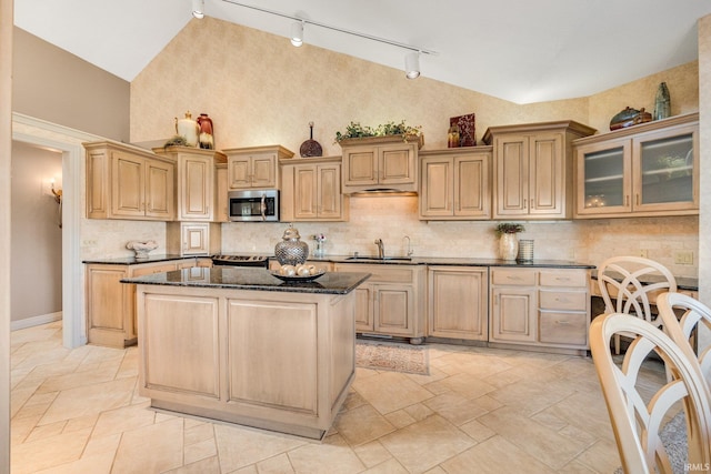 kitchen with glass insert cabinets, stainless steel microwave, and light brown cabinetry