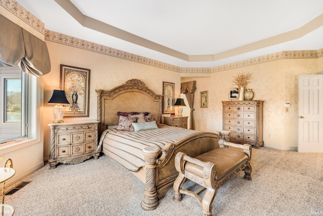 carpeted bedroom with a tray ceiling, visible vents, and baseboards