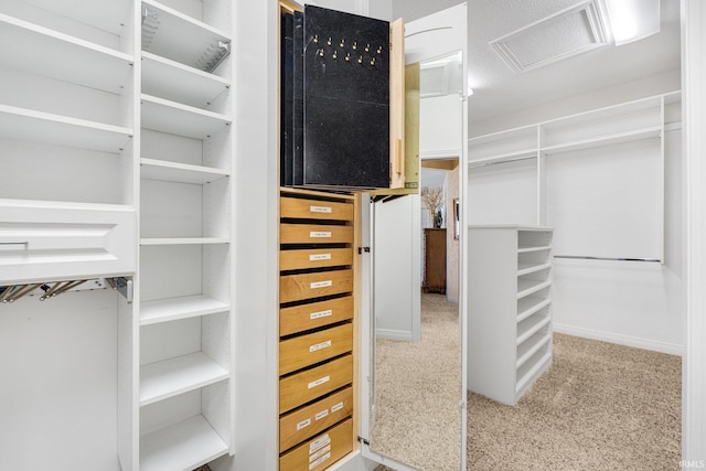 spacious closet with carpet floors, attic access, and visible vents