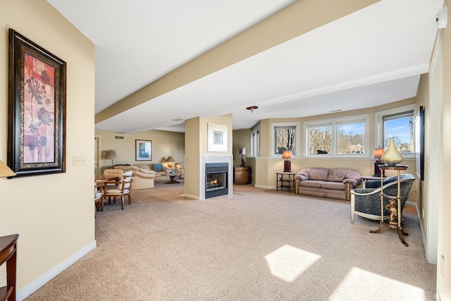 carpeted living area with a fireplace with flush hearth and baseboards