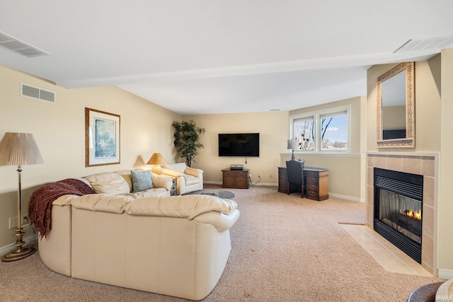 living room featuring light carpet, visible vents, and a tiled fireplace