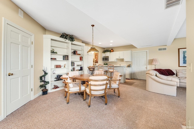 dining room with visible vents and light carpet