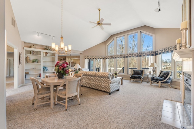 dining room with light carpet, high vaulted ceiling, visible vents, and track lighting