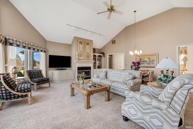 living room featuring carpet, visible vents, rail lighting, a glass covered fireplace, and high vaulted ceiling