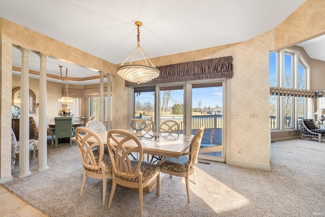 dining space with a water view, carpet flooring, visible vents, baseboards, and decorative columns