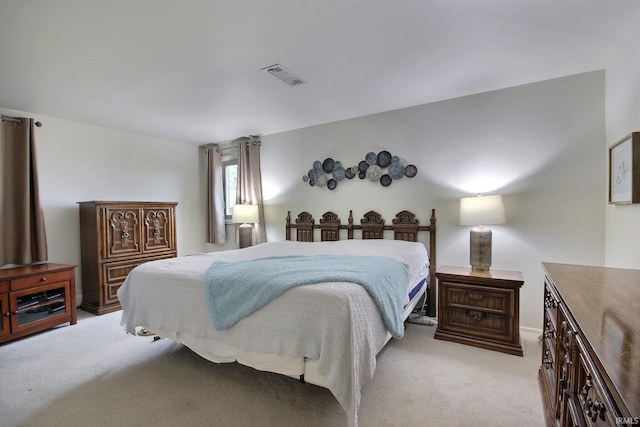 bedroom featuring visible vents and light carpet