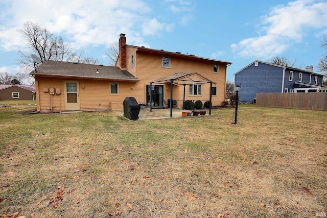 back of house featuring a yard, a chimney, a gazebo, a patio area, and fence