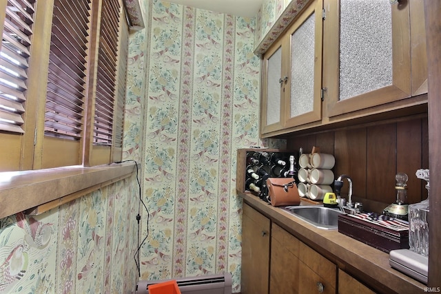 bar featuring a baseboard heating unit and a sink