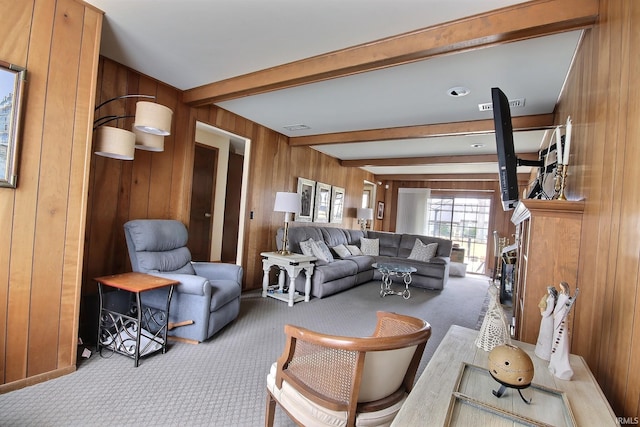 living area featuring wood walls, carpet, visible vents, and beamed ceiling